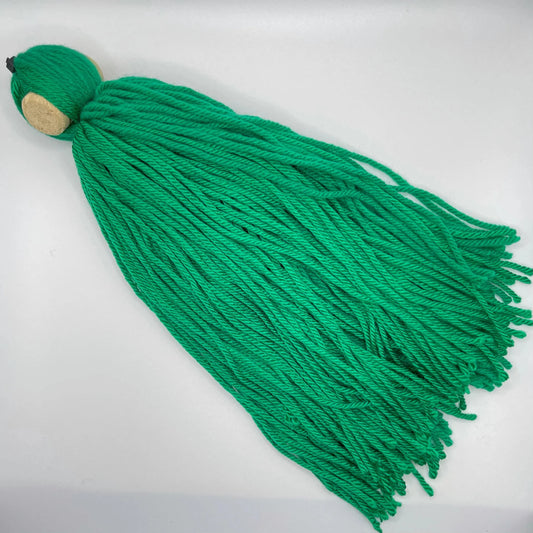 DIY spawning mop made of green acrylic yarn tied to a cork, floating in an aquarium for egg-laying fish